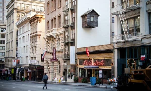 cabaña de madera, colgada de la fachada de un edificio 